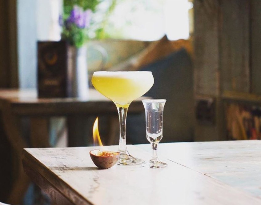 Image of the inside of The Tipsy Bird bar showing a drink on a table 