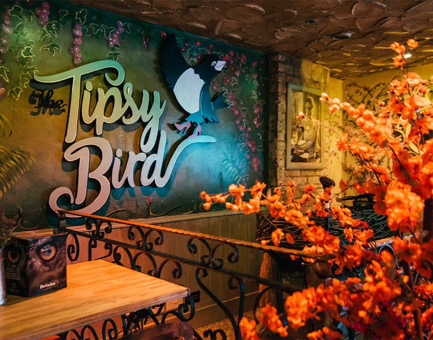 Image of the inside of The Tipsy Bird bar with The Tipsy Bird sign
