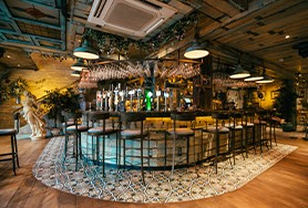Image of the inside of The Tipsy Bird bar with stools at the bar