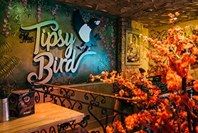 Image of the inside of The Tipsy Bird bar with The Tipsy Bird sign